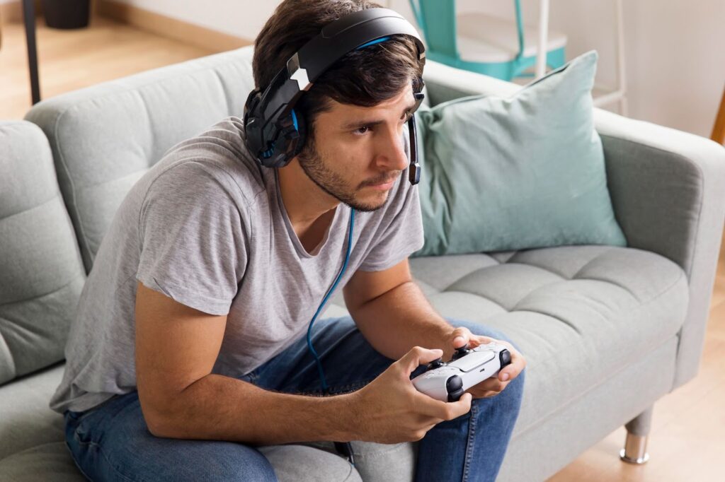 Man playing with controller on sofa