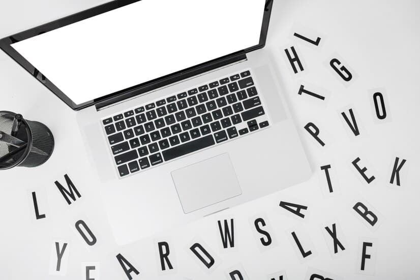 Laptop with Various Alphabets on White Desk